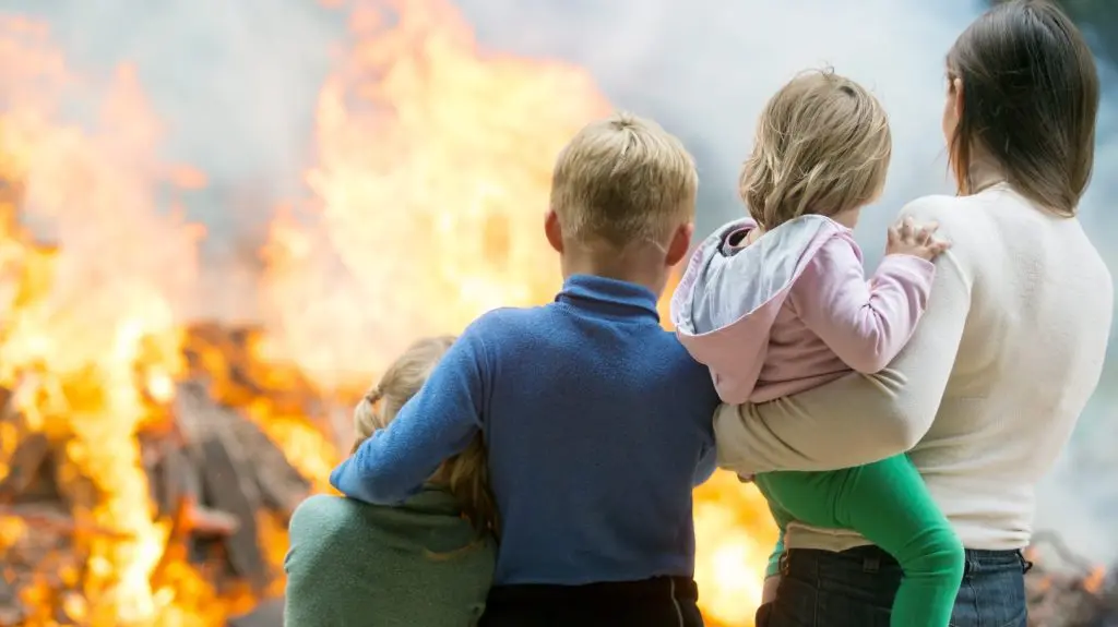A family standing in front of a fire