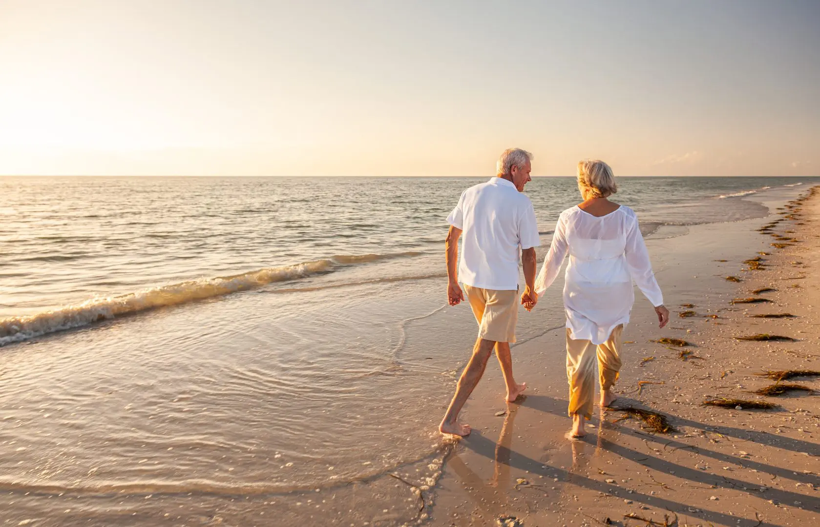Ab elderly couple holding hands on a beach