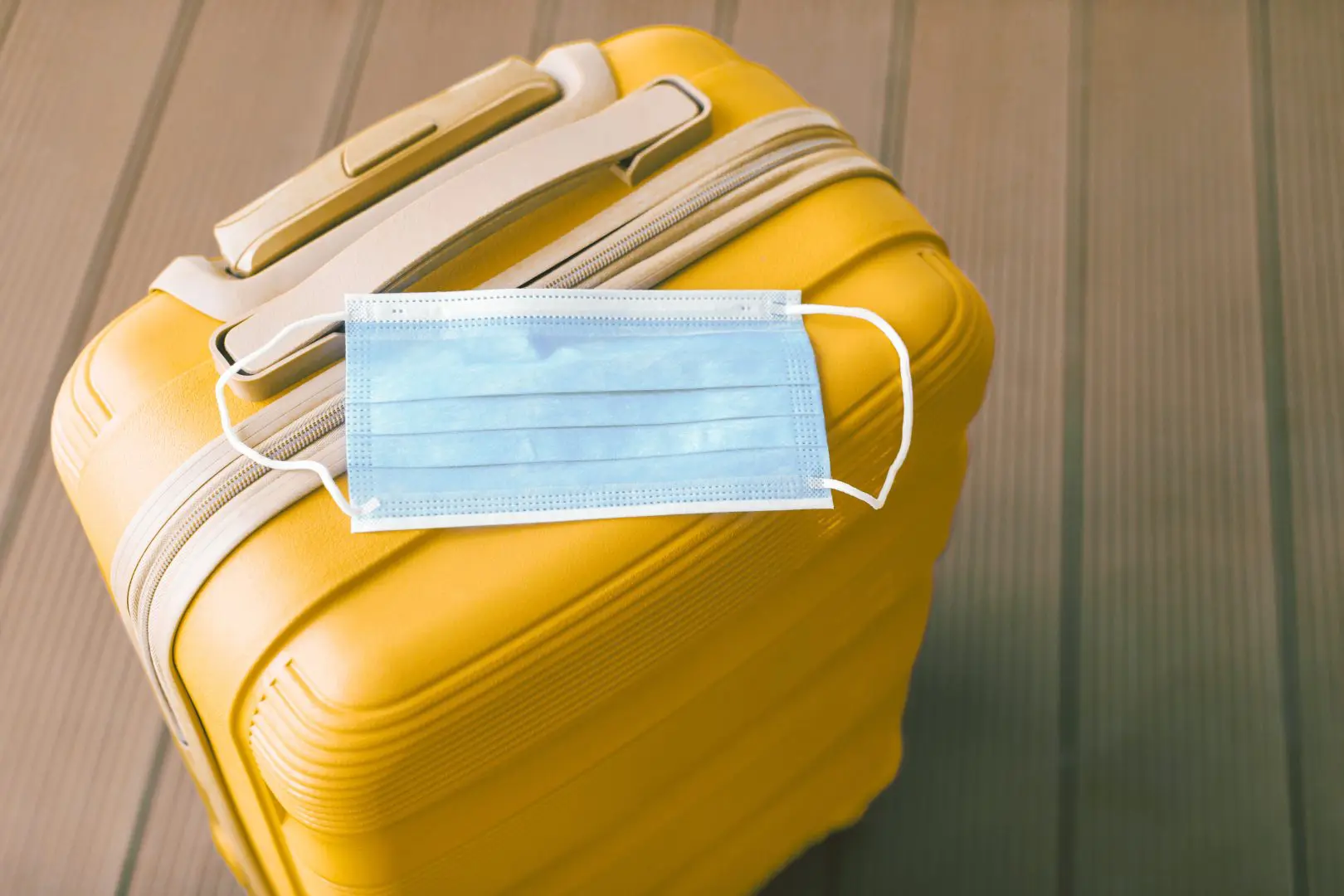 Image of a yellow bag with a green face mask on it