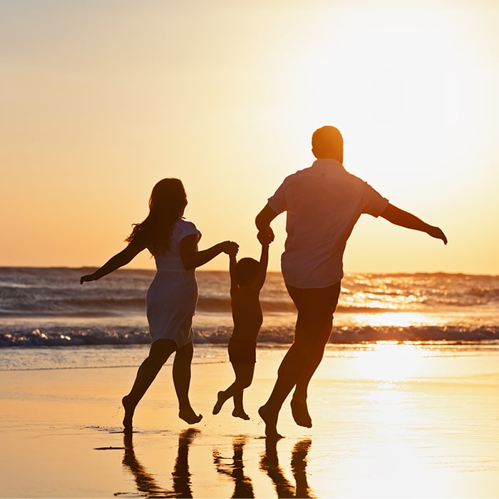 Family on beach at sunset - Norton Insurance Brokers