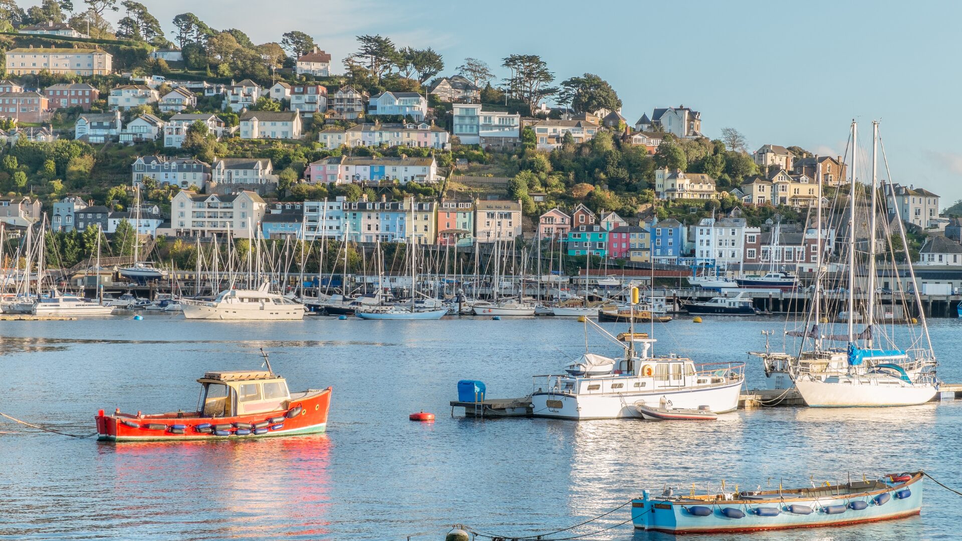 A shot of boats in the sea with Dartmouth, Devon in the background.