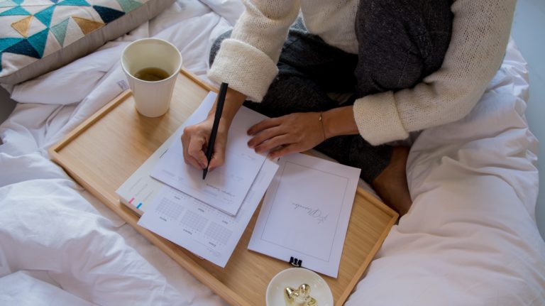 woman on bed with planner