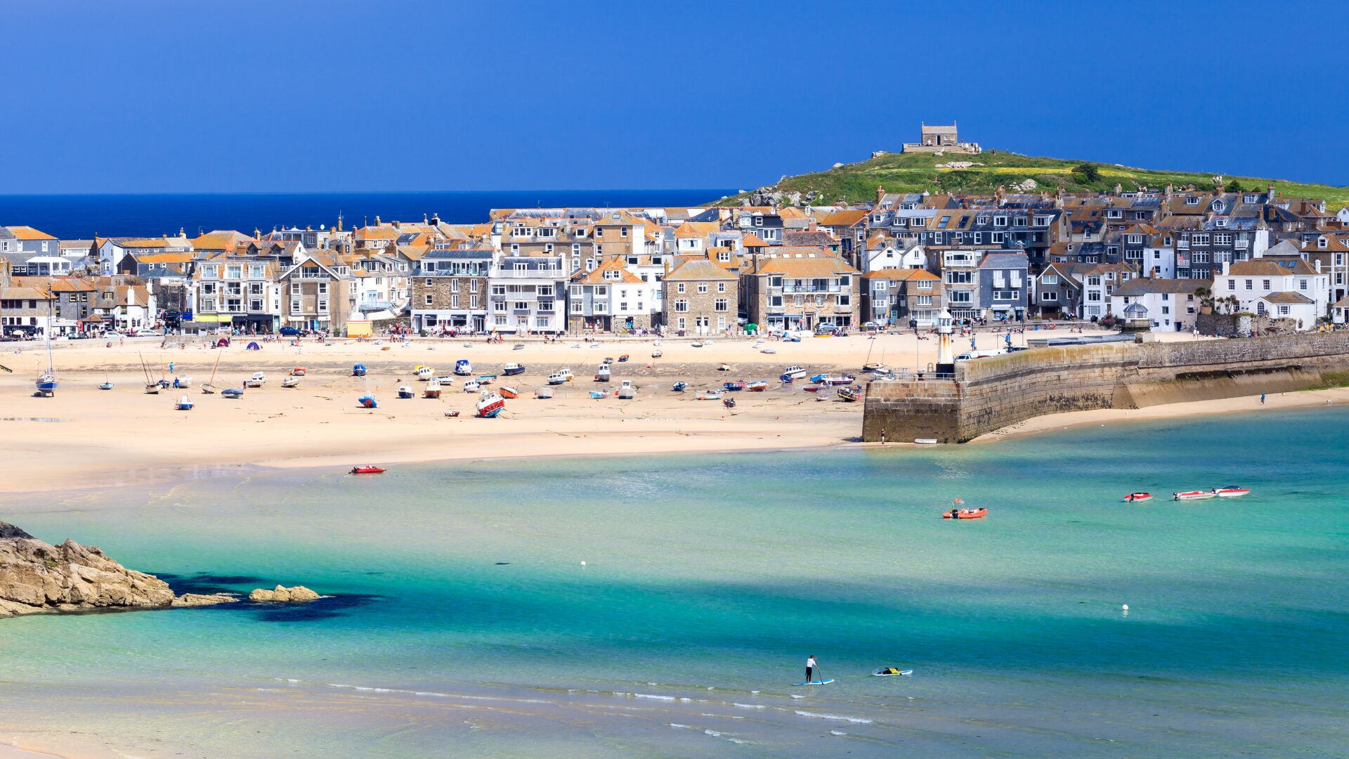 An aerial shot of holiday let properties overlooking the sunny beach in St Ives, Cornwall.