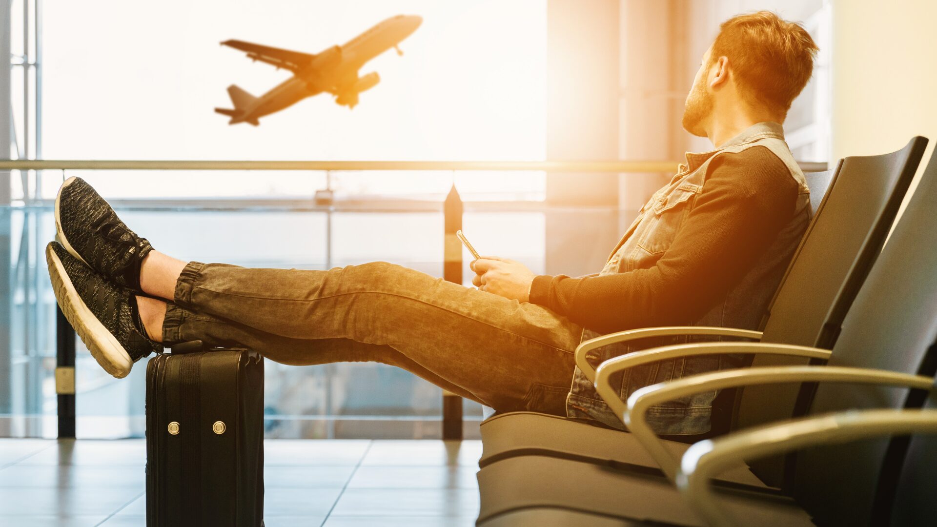 A man relaxing at the airport waiting for his flight.