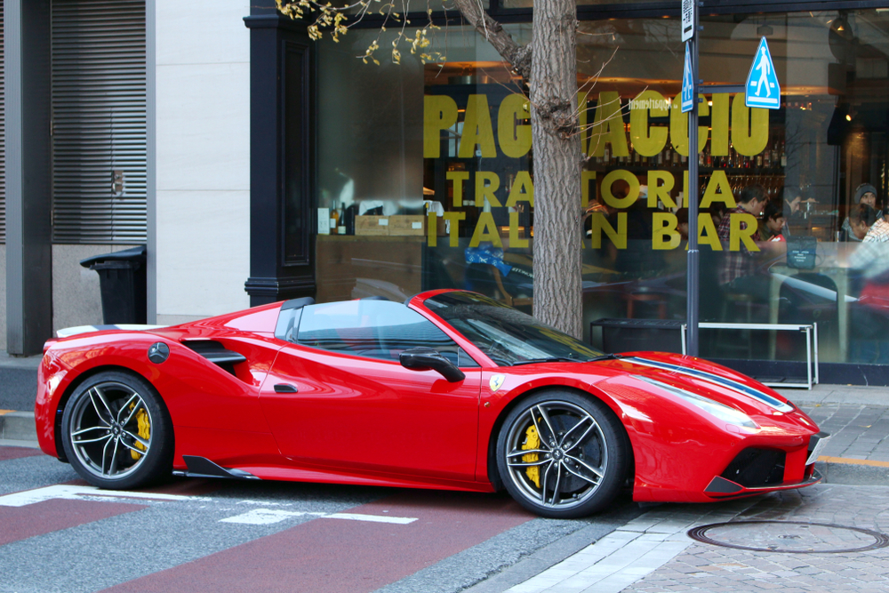 A red Ferrari 488 Spider parked in a street.