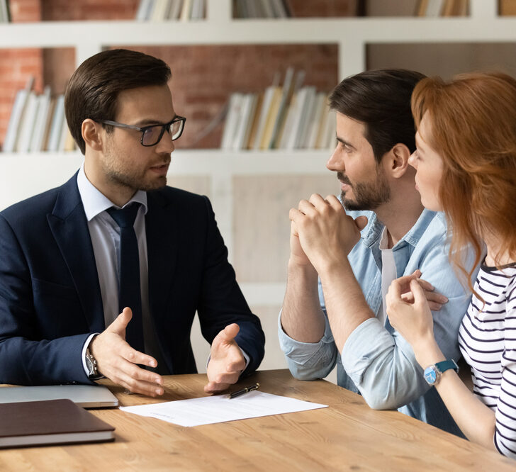 An insurance broker advising a couple on their insurance needs.
