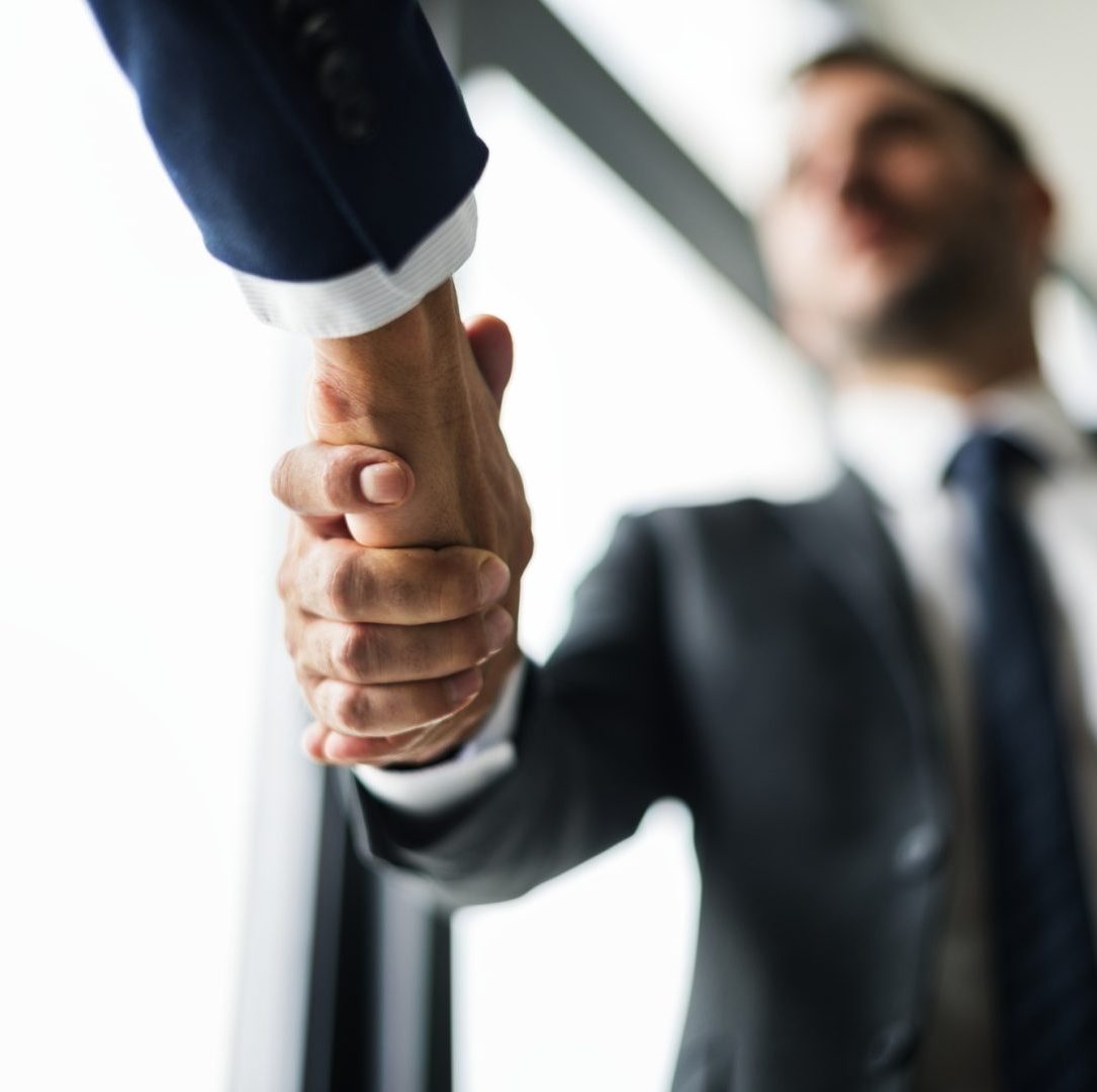 A close up of two people shaking hands.