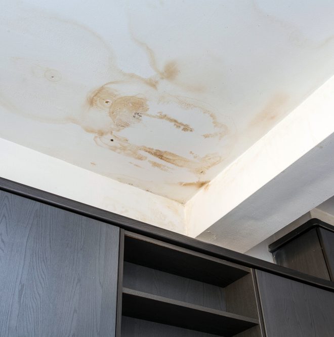 Water damage on a ceiling from a leaking pipe.