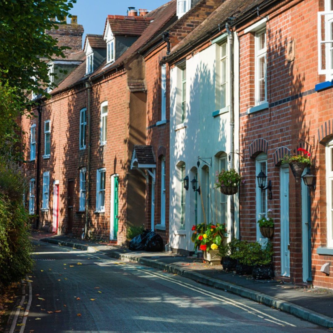A row of rental properties beside a long narrow road in the UK.